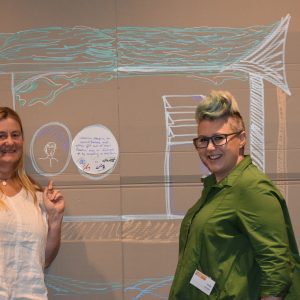 two people in front of a board with images and shapes